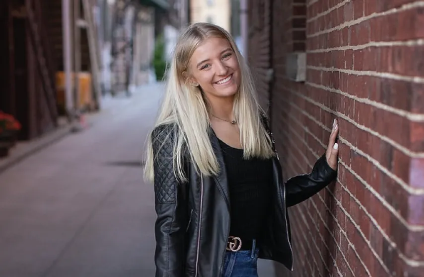 A student posing for a picture outside.